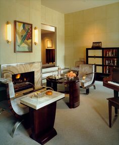 a living room filled with furniture and a fire place in the middle of the room