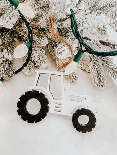 a white tractor ornament sitting on top of a table next to a christmas tree