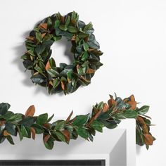 two wreaths are hanging on the wall next to each other, one is made out of fake leaves