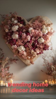 a heart - shaped arrangement with flowers and candles is displayed in front of a wall