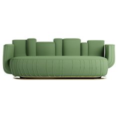 a green couch sitting on top of a wooden table next to a white wall and floor