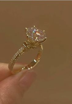 a close up of a person holding a diamond ring