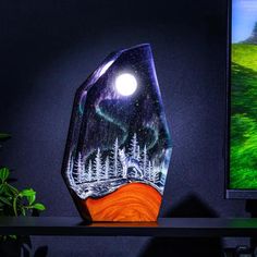 a glass sculpture sitting on top of a table next to a computer monitor and plant