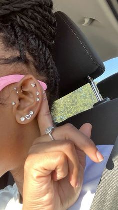 a woman with ear piercings sitting in a car