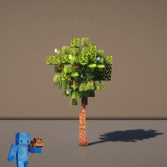 a small tree with lots of green leaves in the middle and a blue dog standing next to it