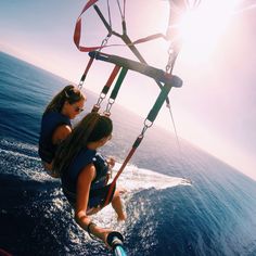 two people riding on the back of a kiteboard