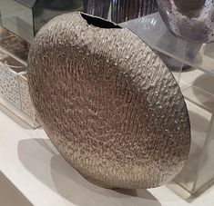 a vase sitting on top of a white table next to other glass containers and bowls