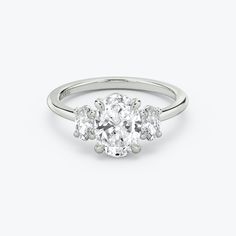 an oval diamond ring with three stones on the side