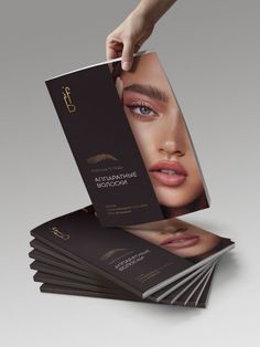 a stack of brochures with a woman's face and eyebrows on them