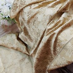 a bouquet of white flowers sitting on top of a bed next to a comforter