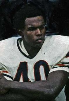 a football player sitting on the sidelines with his arms crossed in front of him