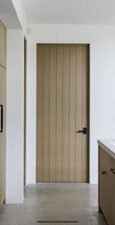 an empty kitchen with wooden doors and counter tops