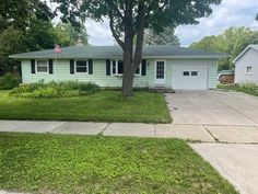 a house that has grass in front of it and a flag on the side of the house