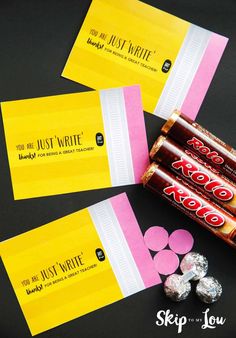 three candy bar wrappers sitting next to each other on top of a black table