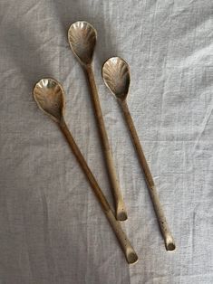 three wooden spoons sitting on top of a white sheet