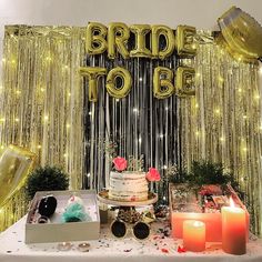 a table topped with a cake and candles next to a sign that says bride to be