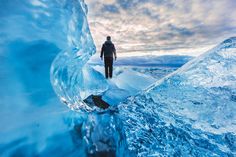 a man standing on top of an ice cave