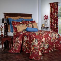 a bed room with a neatly made bed and red floral bedspread on it