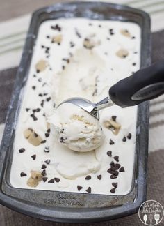 an ice cream sundae with chocolate chips on it and a spoon in the middle