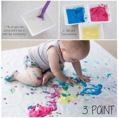 a baby playing with paint on the floor