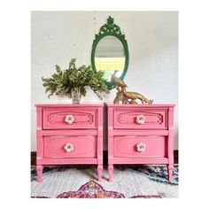 pink dresser with mirror and plants on top