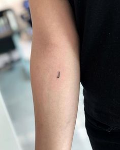 a person with a small tattoo on their arm that reads'j'in cursive writing