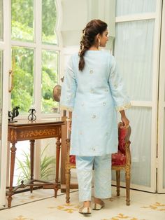 Set of 3 consists of kurta, pant and inner. Noor, bringing the magic of festivities straight to your closet in shades of pastels. Kurta: A elegant powder blue short chanderi kurti with heavy gota lace detailing on the neckline, sleeves & hemline. Comes with an inner. Pants: Straight fit cotton silk pants adorned with gota detailing. Occassion: Day Wear, Evening Wear, Festive Wear Fabric: Chanderi Wash Care Instructions: Dry Clean Only Note: The product will be shipped within 15-20 days of th Festive Wear, Embroidered Neckline, Silk Pants, Silk Embroidery, Indian Designer Wear, Kurta Set, Cut Work, Pants Straight, Indian Design