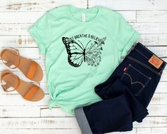 "Featuring a graceful butterfly graphic, Give your casual-day outfit a pop of personality with this breathable tee made with a fitted cut and soft cotton blend. Comes in many colors. This unisex essential fits like a well-loved favorite, featuring a crew neck, short sleeves, and a classic fit. Dual sideseams ensure better fit over time. Designed with superior combed and ring-spun cotton, dyed and cut in the US, these customizable shirts act as the best blank canvas for printing. *  If you are lo Inspirational Relaxed Fit T-shirt For Spring, Inspirational Graphic Print T-shirt For Summer, Inspirational Graphic Print Tops For Summer, Inspirational Graphic Print Summer Tops, Inspirational Summer Graphic Print T-shirt, Inspirational Summer Graphic T-shirt, Inspirational Screen Print T-shirt For Summer, Quote Tshirts, Moms Birthday