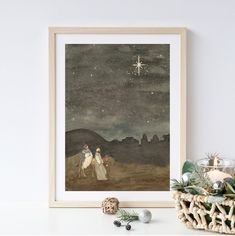 a christmas card with a nativity scene in the background, and a candle next to it