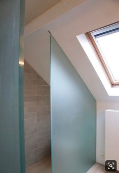 an empty room with a skylight in the corner