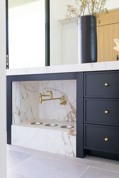 a bathroom with marble counter tops and gold faucets