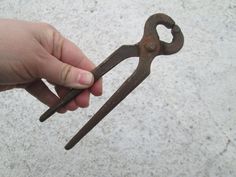 a hand holding an old rusty pair of scissors