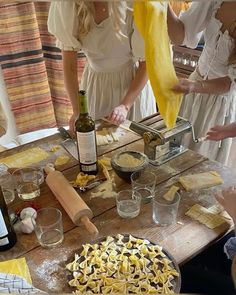 people are gathered around a table with food and wine