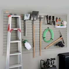 there is a ladder and tools hanging on the wall