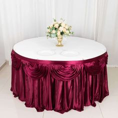 a white table topped with a vase filled with flowers