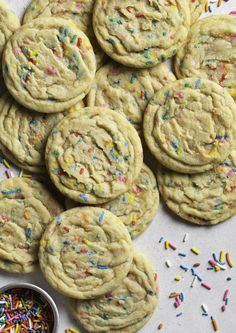 sprinkle covered cookies are sitting on a table with sprinkles around them