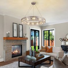 a living room filled with furniture and a fire place under a chandelier hanging from the ceiling