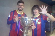 two soccer players are posing with the trophy