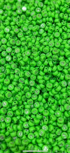 green beads with white letters and numbers are shown in this close up photo, as well as the words on each bead