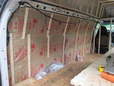 the inside of a van is being built with wood and electrical wires in place for insulation