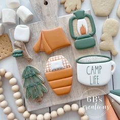 some cookies are laying out on a table with other items around them and the words camp life written in white