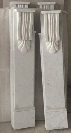 two white marble pedestals sitting next to each other