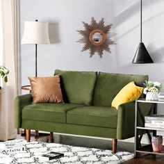 a living room with a black couch and white rug on the floor next to a window