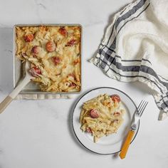 a white plate topped with pasta next to a casserole dish