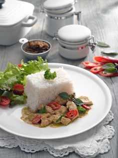 a white plate topped with rice and veggies next to other dishes on a table