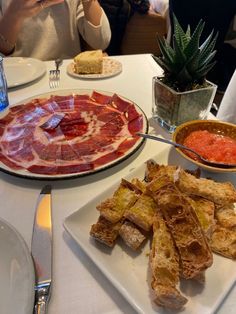 a white table topped with plates of food