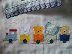 a close up of a piece of cloth with animals on it and a train in the background