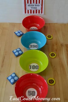 a row of colorful bowls sitting on top of a wooden floor next to numbers and dices