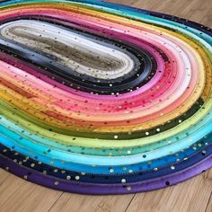 a multicolored round rug with sequins on the top and bottom half