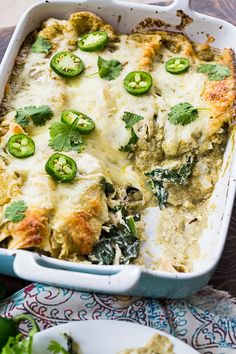 a casserole dish with green peppers and cheese on top, next to a salad